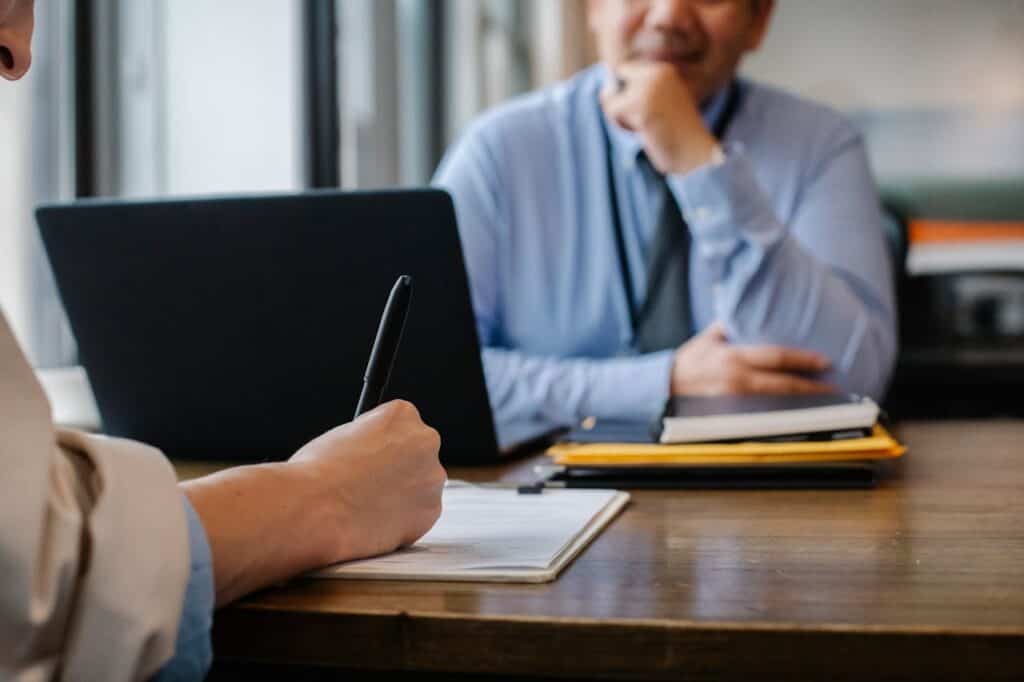 Owner discussing a strata management proposal across a desk